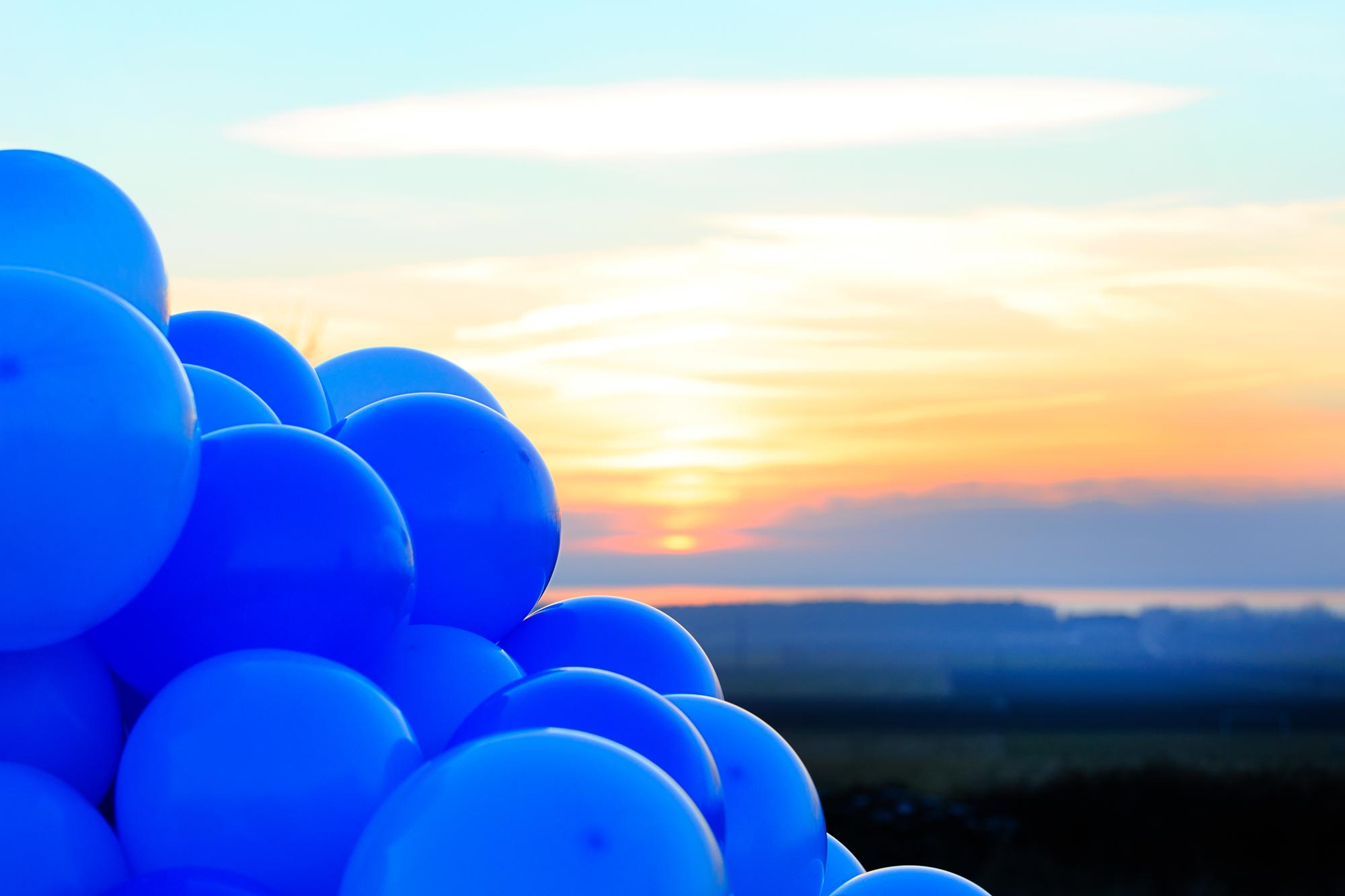 Bild på blå ballonger i solnedgång